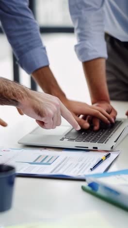 business people are working on a laptop together in office.