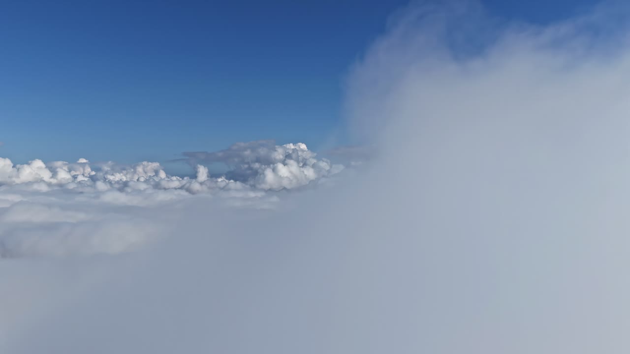 Luftfoto af tåge, skyer og en blå himmel.