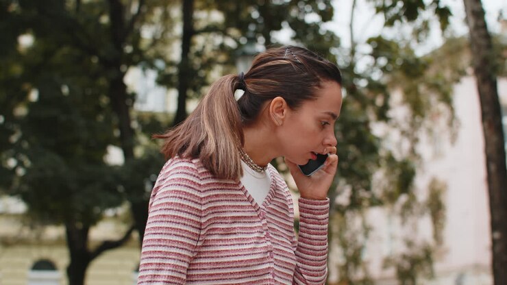 Donna arrabbiata, pazza, stressata, che discute mentre parla sullo smartphone, conversazione irritata, urla, litigio.