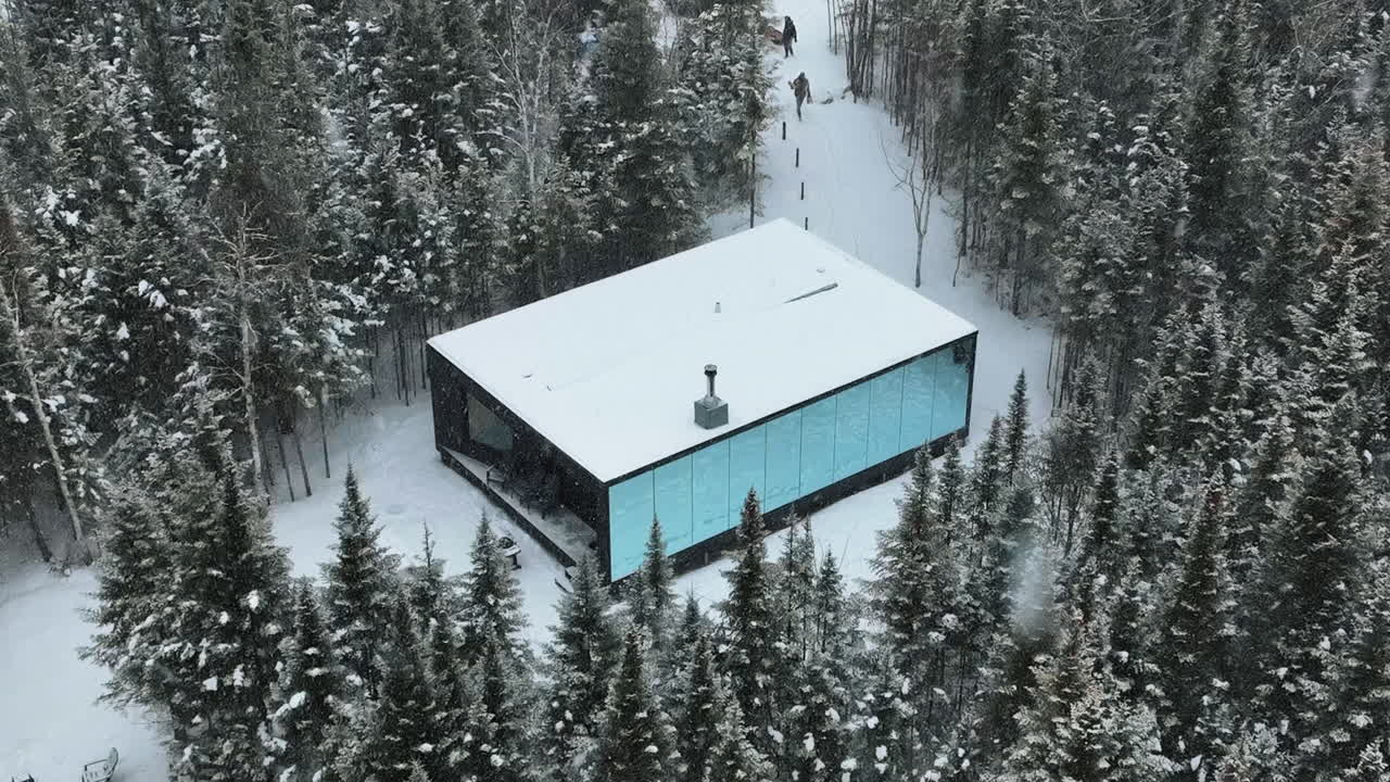 lujosa instalación de cabina de espejo de reflexión durante la tormenta de nieve en charlevoix, quebec, canadá