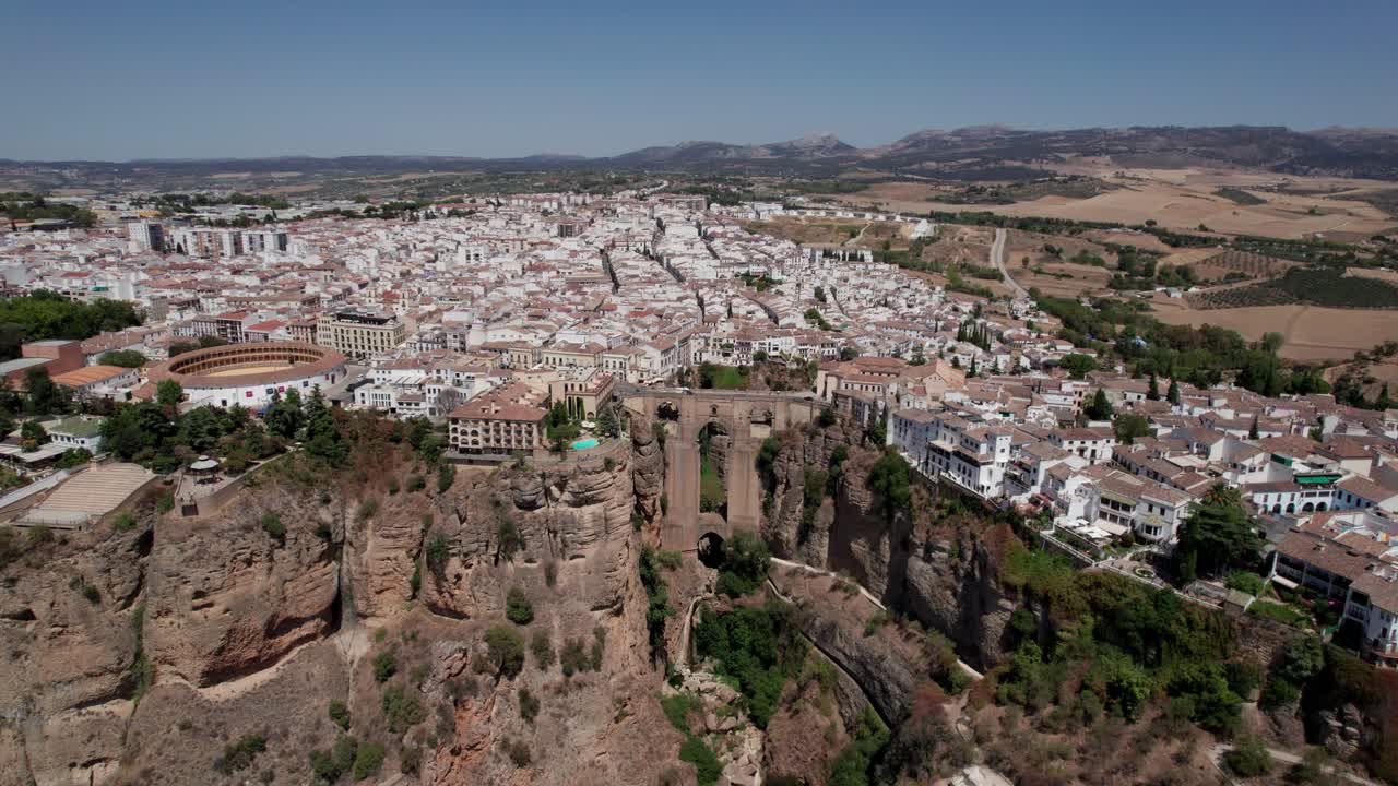 Luftvideo med tilt ned af Puente Nuevo-broen over Tajo de Ronda-kløften og tyrefægterarenaen i Ronda, Andalusien, Spanien.