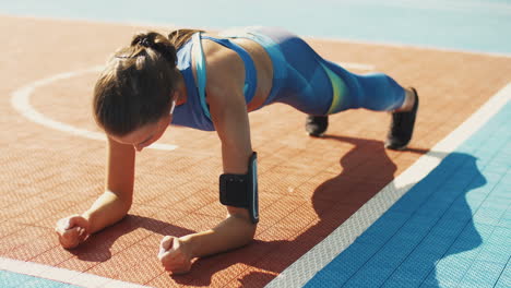 focused fitness girl doing plank exercise at sport court on a summer day 1