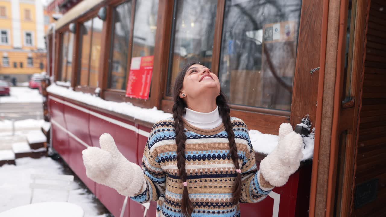 chica jugando en la nieve fuera de un café