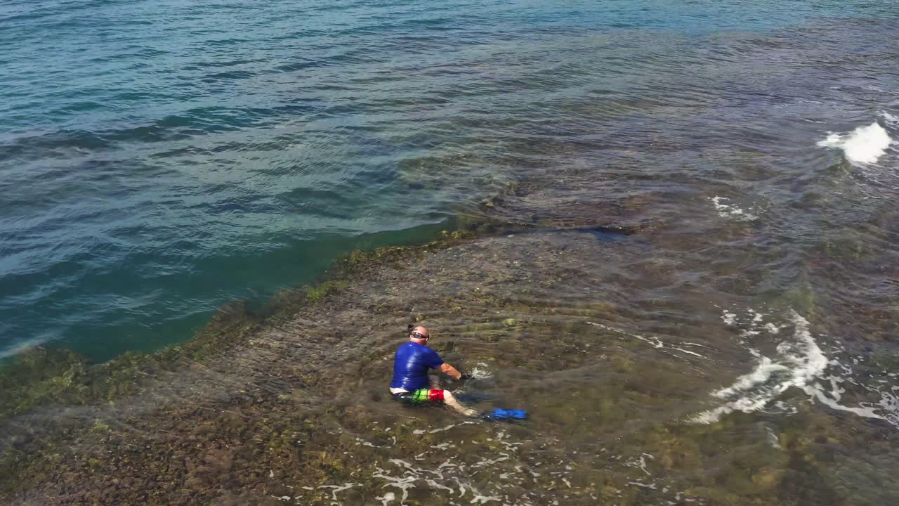 휴가 중 수중 스노클링 활동을 다이빙할 준비가 된 얕은 산호초에 있는 남자