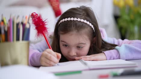 niña joven dibujando o escribiendo en casa