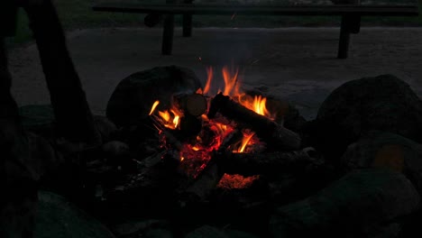 un plano medio de una hoguera iniciada en un campamento
