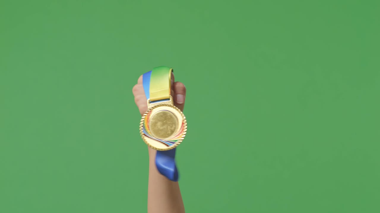 medalla de oro en la mano. fondo de pantalla verde