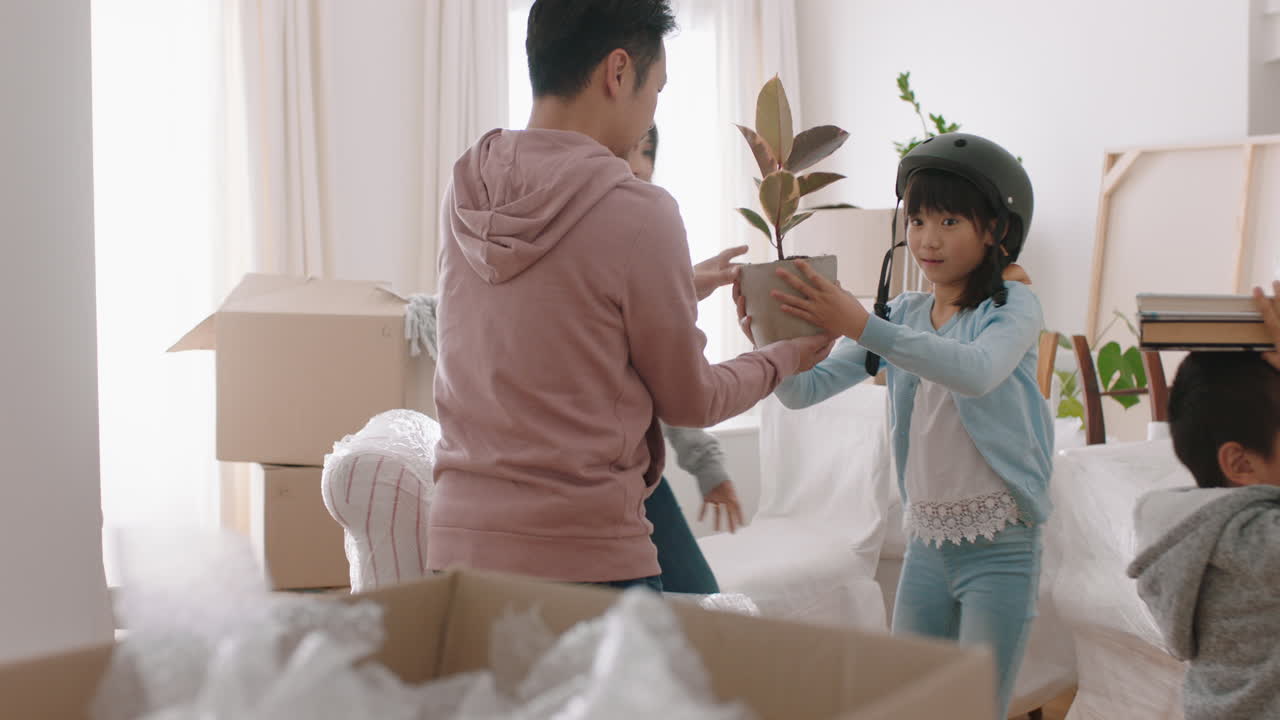 행복한 아시아 가족이 새로운 집으로 이사합니다. 아이들과 함께 부모님을 도와 집으로 이사합니다. 상자를 들고 아이들과 함께 팀워크를 즐기고 부동산 투자 4k 영상