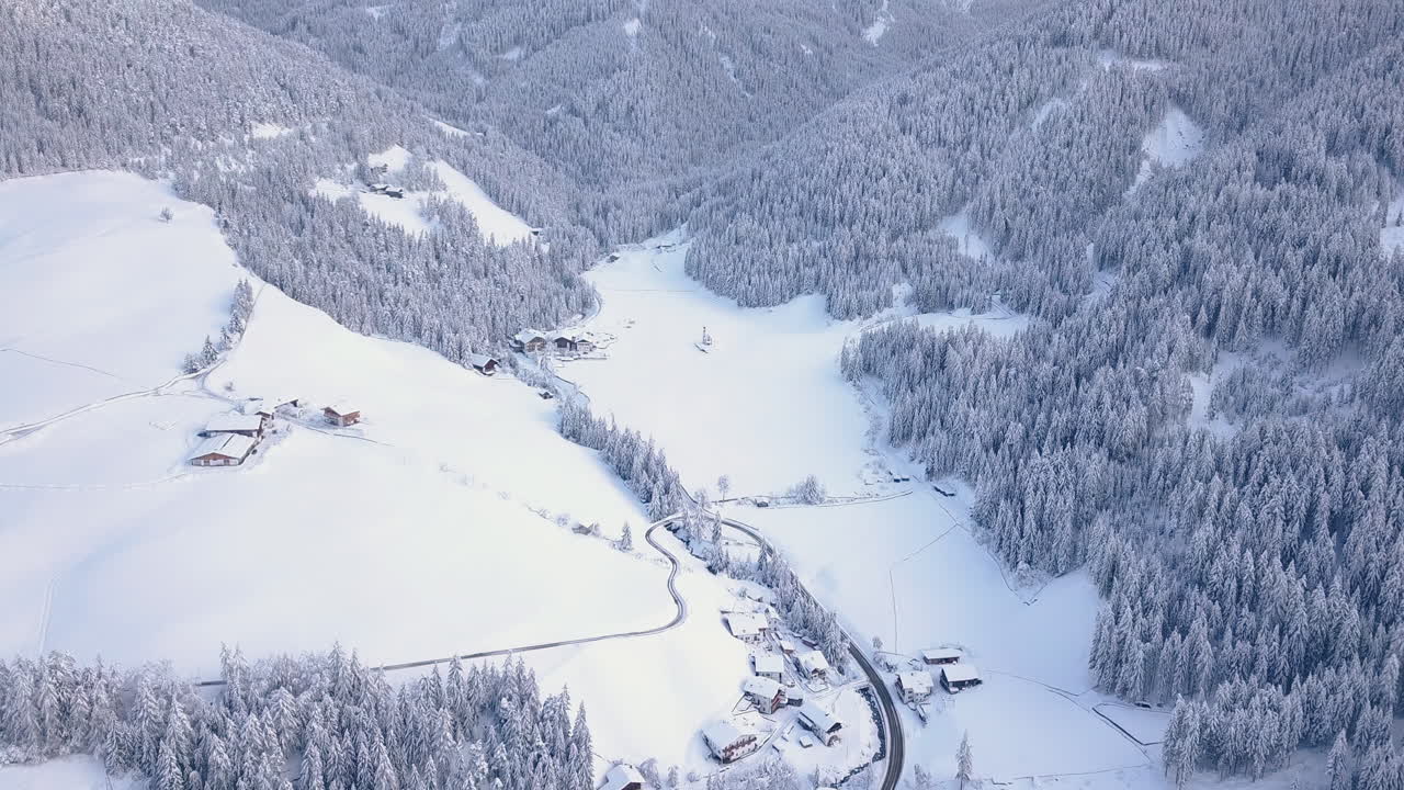 la escarpada cordillera de los dolomitas en la niebla sobre el pueblo cubierto de nieve