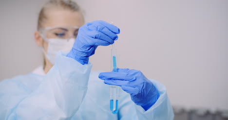 doctor carefully drips medicine from pipette into sample glass tubes for dna analysis at laboratory