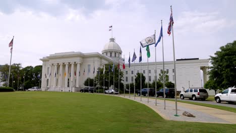 Alabama-state-capitol-building-in-Montgomery,-Alabama-with-gimbal-video-showing-flags-walking-forward-in-slow-motion