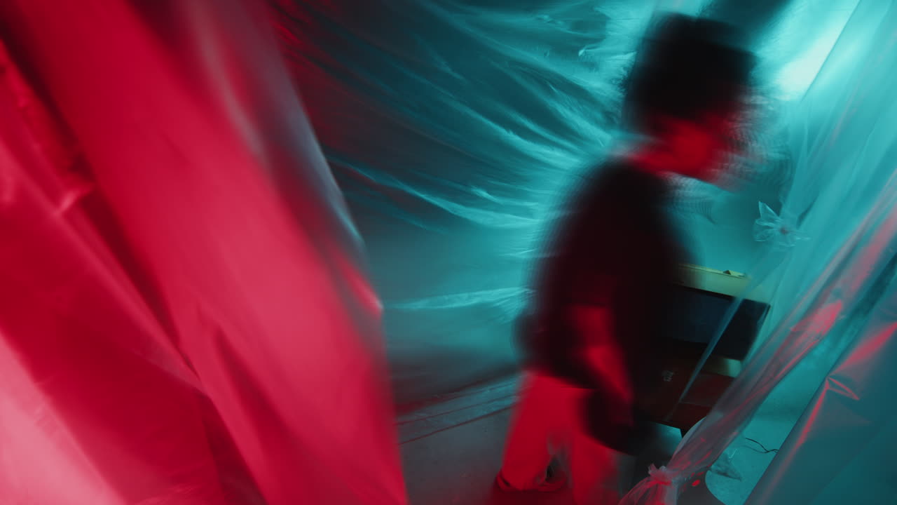 Asian Girl in Retro Tracksuit Wandering around Dark Studio with Neon Light