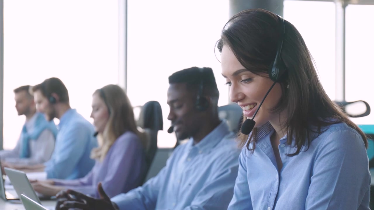 Agente de atendimento ao cliente falando no headset em um escritório moderno