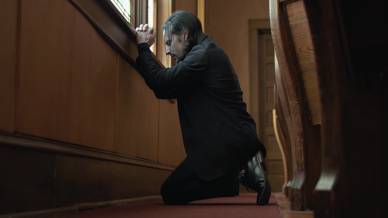 A Christian man, priest, preacher, pastor in spiritual reflection and worship while praying inside old church building, creating a cinematic and contemplative mood
