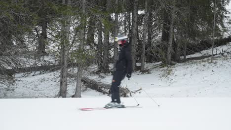 group of beginner skiers slowly skiing by the camera downhill in a line on a cloudy winter day at a ski resort in norway