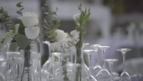 Rosas-Blancas-En-La-Mesa-Sopladas-Por-El-Viento-En-La-Recepción-De-La-Boda-Al-Aire-Libre-En-Un-Día-Ventoso,-De-Cerca,-A-Cámara-Lenta