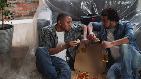 african-american man talks to black friend while eats pizza