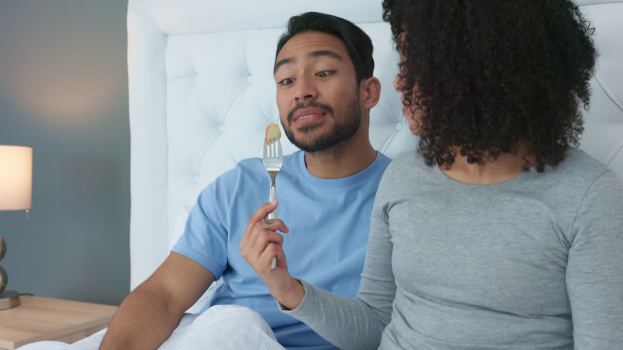Couple, bedroom and woman feeding man in home