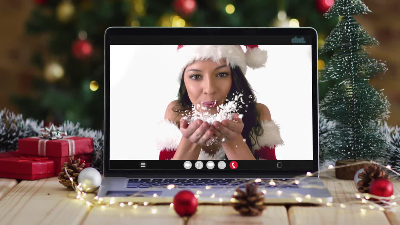 feliz mujer caucásica en disfraz de santa en videollamada en computadora portátil, con decoraciones de navidad y árbol