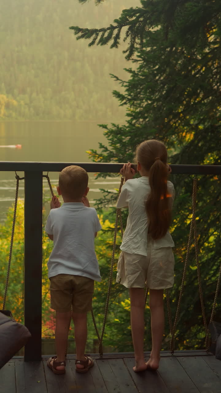 아이들은 물 교통과 주변 산의 호수 전망을 감탄합니다. 가을에 글램핑 플렉스를 가진 관광객을위한 시골 호텔에서 가족 레크리에이션