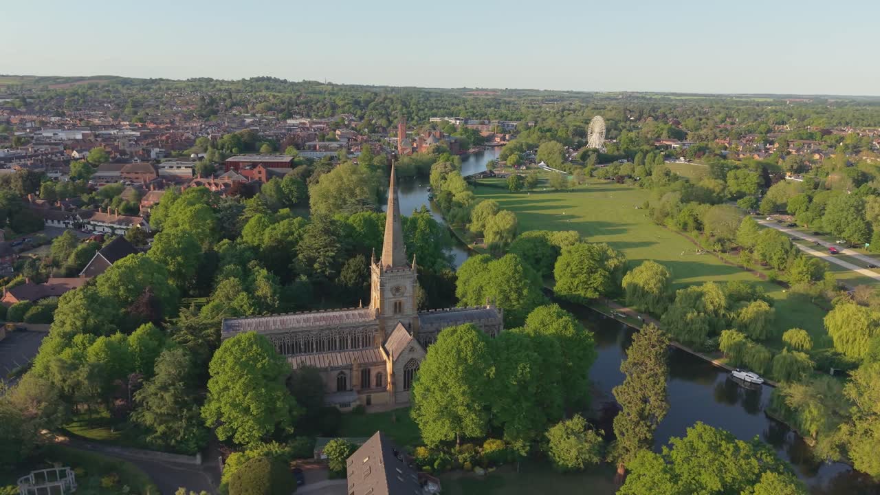 Et droneopptak som følger over elven Avon, fanger den travle byen Stratford-upon-Avon og avslører den majestetiske gotiske Holy Trinity Church bak vårlig grønt.