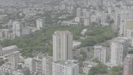 santo domingo, dominican republic – june 22, 2025: aerial drone footage capturing a large modern building with the city skyline of santo domingo in the background, 4k raw color video.