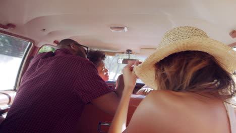 group of friends relaxing in car during road trip