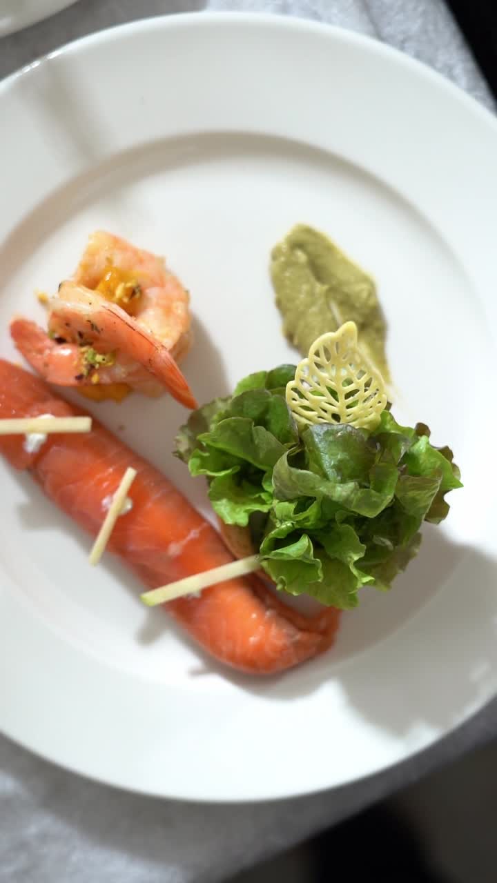 View of plated shrimp dish with colorful peppers, garnished with a yellow sauce, close up shot