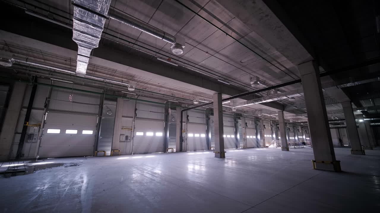 Stort og moderne lager under opførelse, med metalreoler og andet industrielt udstyr.