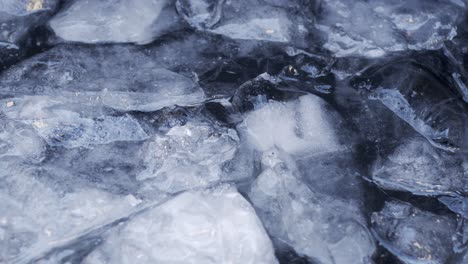 Agua-Helada-Fría-Moviéndose-En-Un-Lago-Con-Trozos-De-Hielo-Flotando