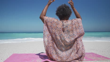 Ältere-Frau-Macht-Yoga-Am-Strand