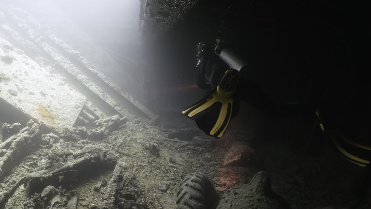 Scuba diver swimming inside the boat wreck Thistlegorm in the red sea in 4k