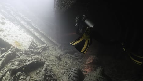 scuba diver swimming inside the boat wreck thistlegorm in the red sea in 4k