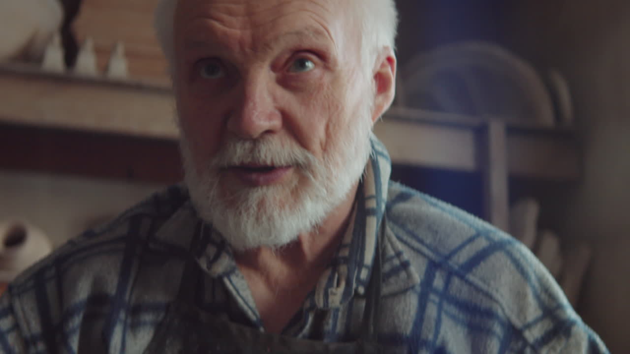 Senior Potter Throwing Vase on Wheel in Workshop