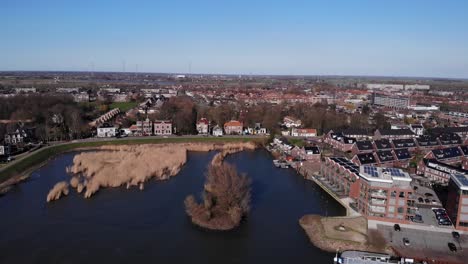 Aerial-View-Of-Alblasserdam-Town-With-Ferry-Terminal-By-Noord-River-In-South-Holland,-Netherlands