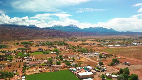 aerial over desert community with snow-covered mountain peaks in the background