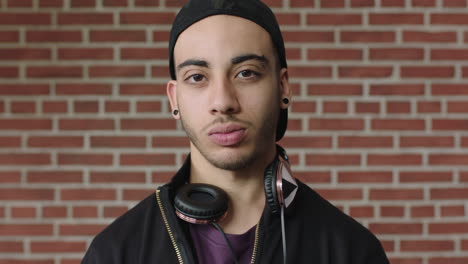 portrait of confident hispanic man looking serious student wearing headphones