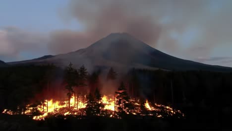 majestic volcanic landscape erupts into wildfire chaos with flames engulfing forested area underneath the towering mountain peak