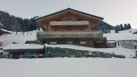 dynamic shot of a luxurious car driving into parking garage of expensive chalet in rural switzerland