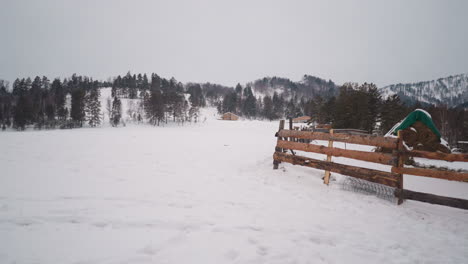 Wooden-fencing-of-farm-located-in-scenic-snowy-highland