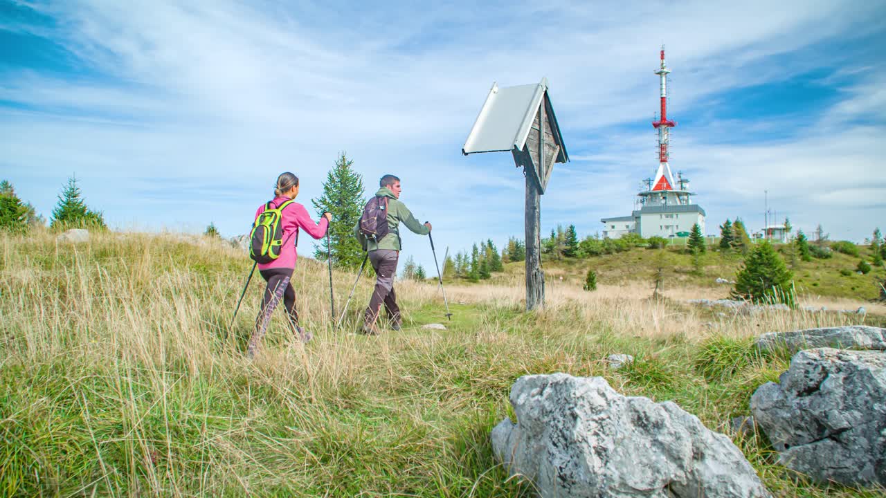 Young couple hikers with backpacks, enjoying their adventure. low angle