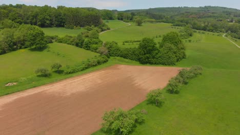 flying over rolling hills with fields in a rural countryside