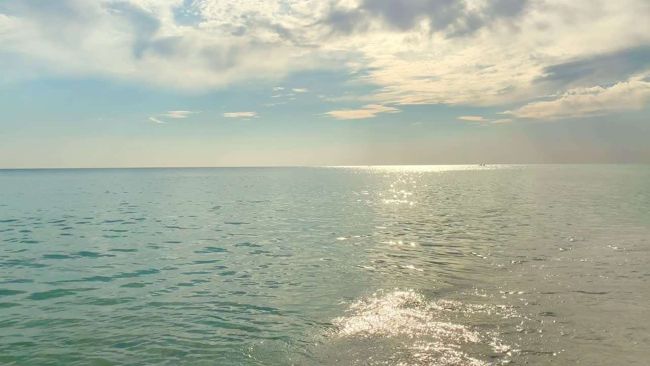 해안을 강타하는 부드러운 파도에 화려한 햇빛