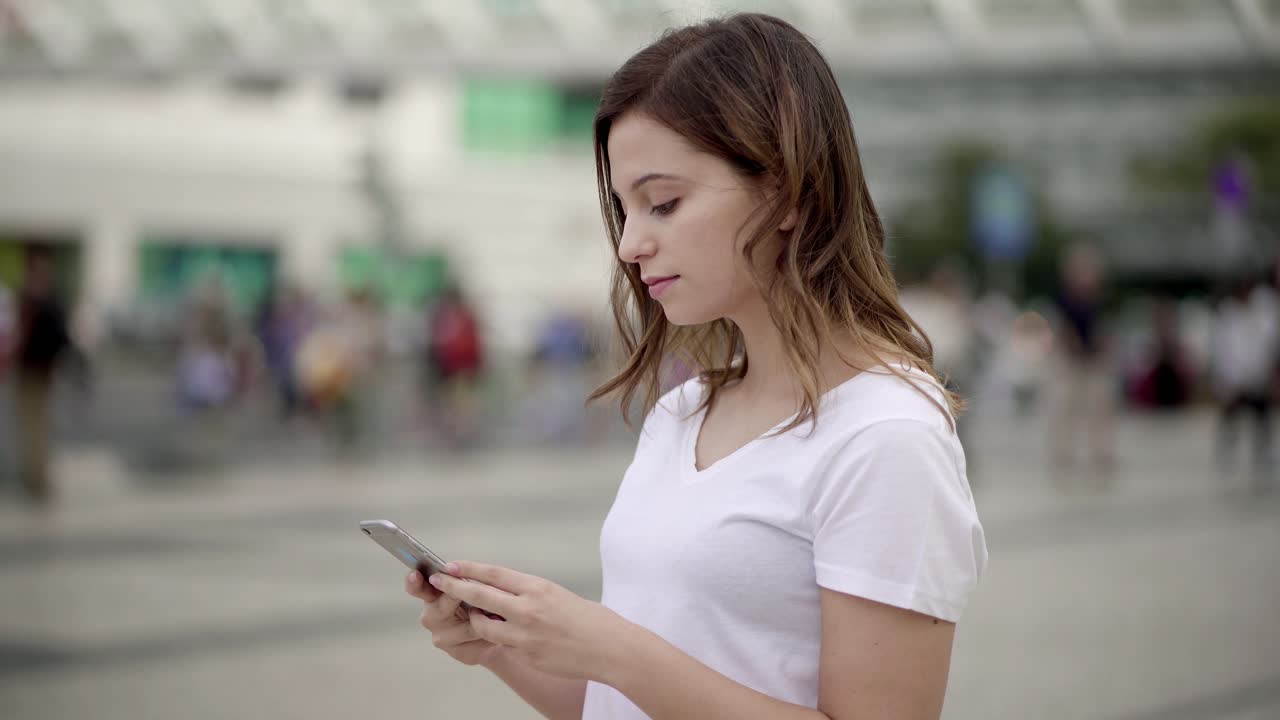 Bellissima giovane donna che usa lo smartphone per strada