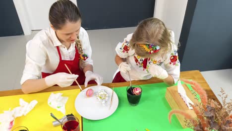 mother and daughter decorating easter eggs