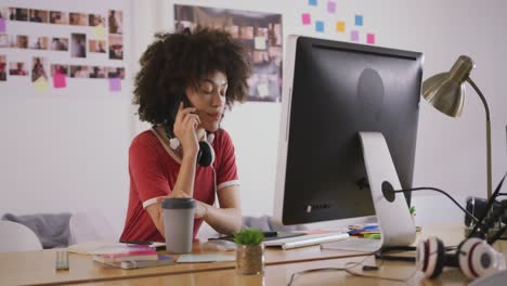 mujer de raza mixta llamando a la oficina creativa