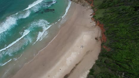 Olas-Espumosas-Chapoteando-En-La-Orilla-Arenosa-De-La-Playa-De-Broken-Head-En-Nueva-Gales-Del-Sur,-Australia---Toma-Aérea