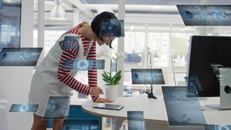 animación de radares, gráficos y lenguaje informático sobre mujer asiática usando tableta digital en la oficina