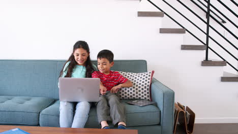 Hermano-Y-Hermana-Sentados-En-El-Sofá-De-Casa-Usando-Una-Computadora-Portátil