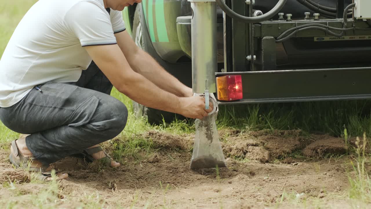 에 검은 토양을 넣는 사람. 농학의 토양 검사. 지질공학적 조사. 검은 땅을 검사 및 분석을 위해 현장에서 수집하는 것. 픽업에 대한 특수 장비.
